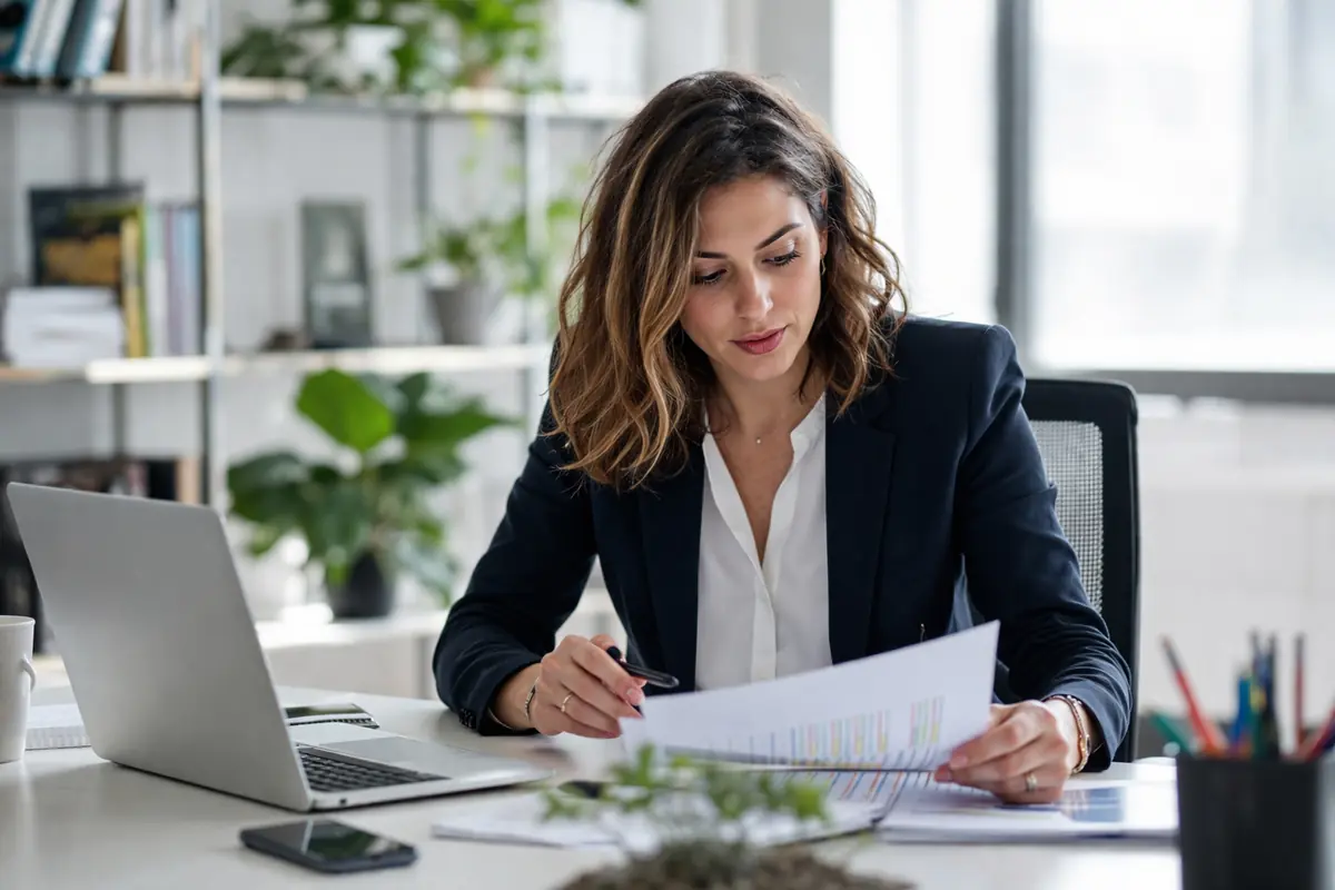 donna che lavora in ufficio con documenti e laptop rappresentazione imprenditoria femminile in Italia